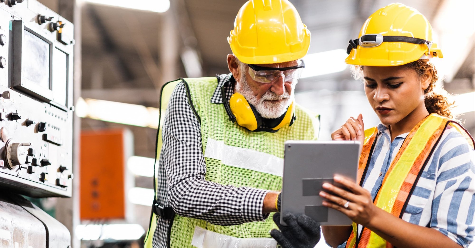 two manufacturing employees looking at data on a tablet