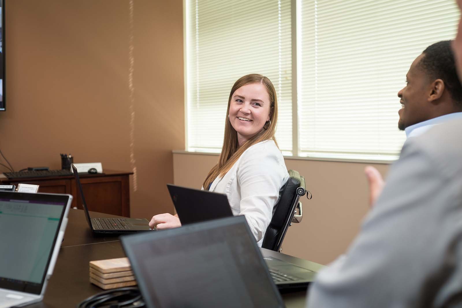 Woman in office, sitting at a table.