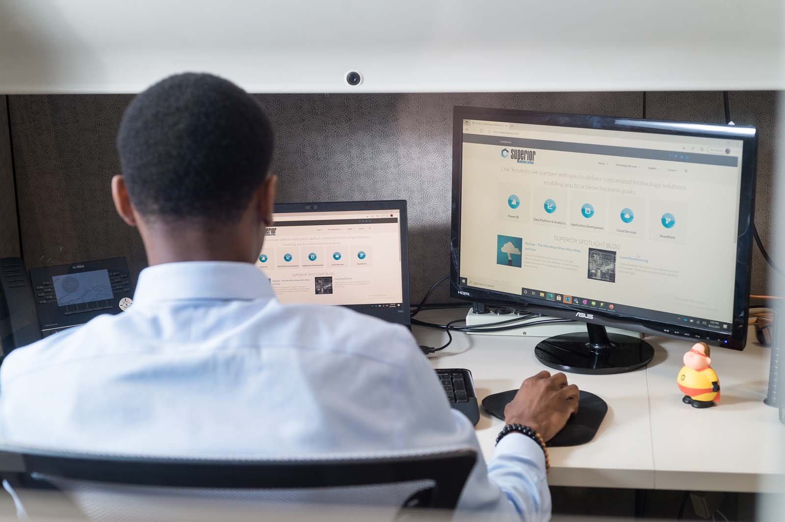 Man working on two computer screens