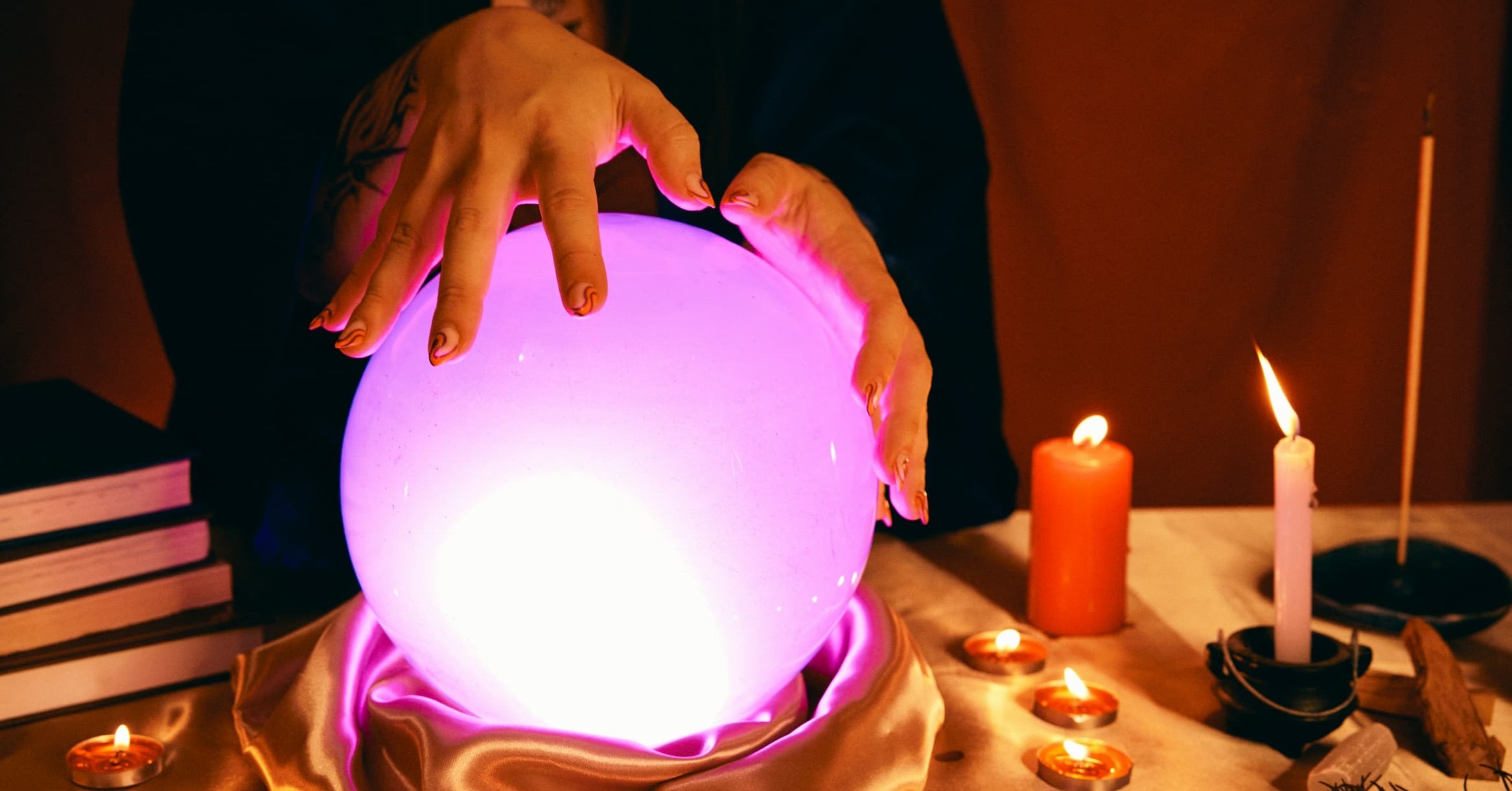 a person touching a glowing crystal ball on a table