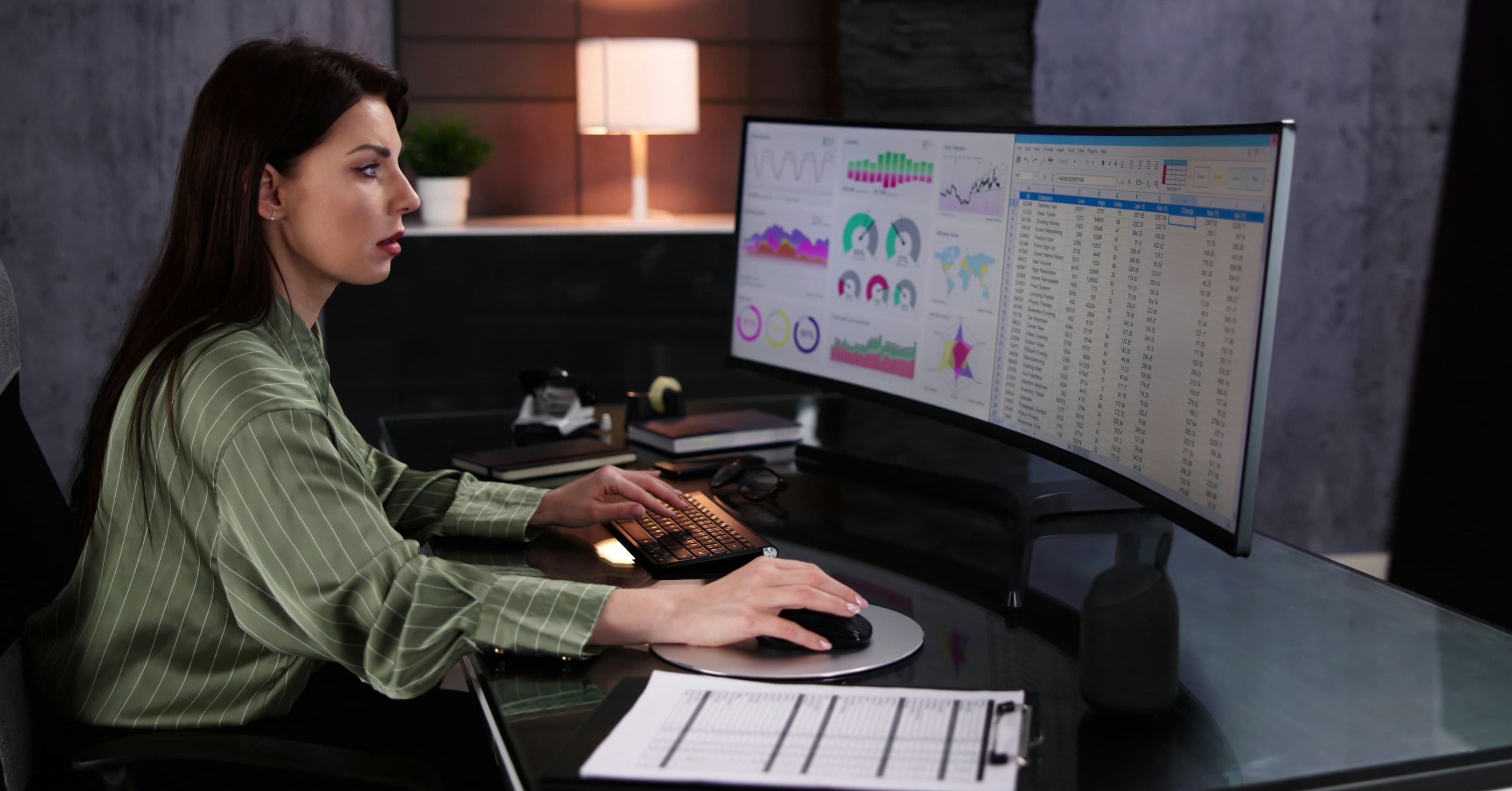 a data analyst reviewing reports on a monitor