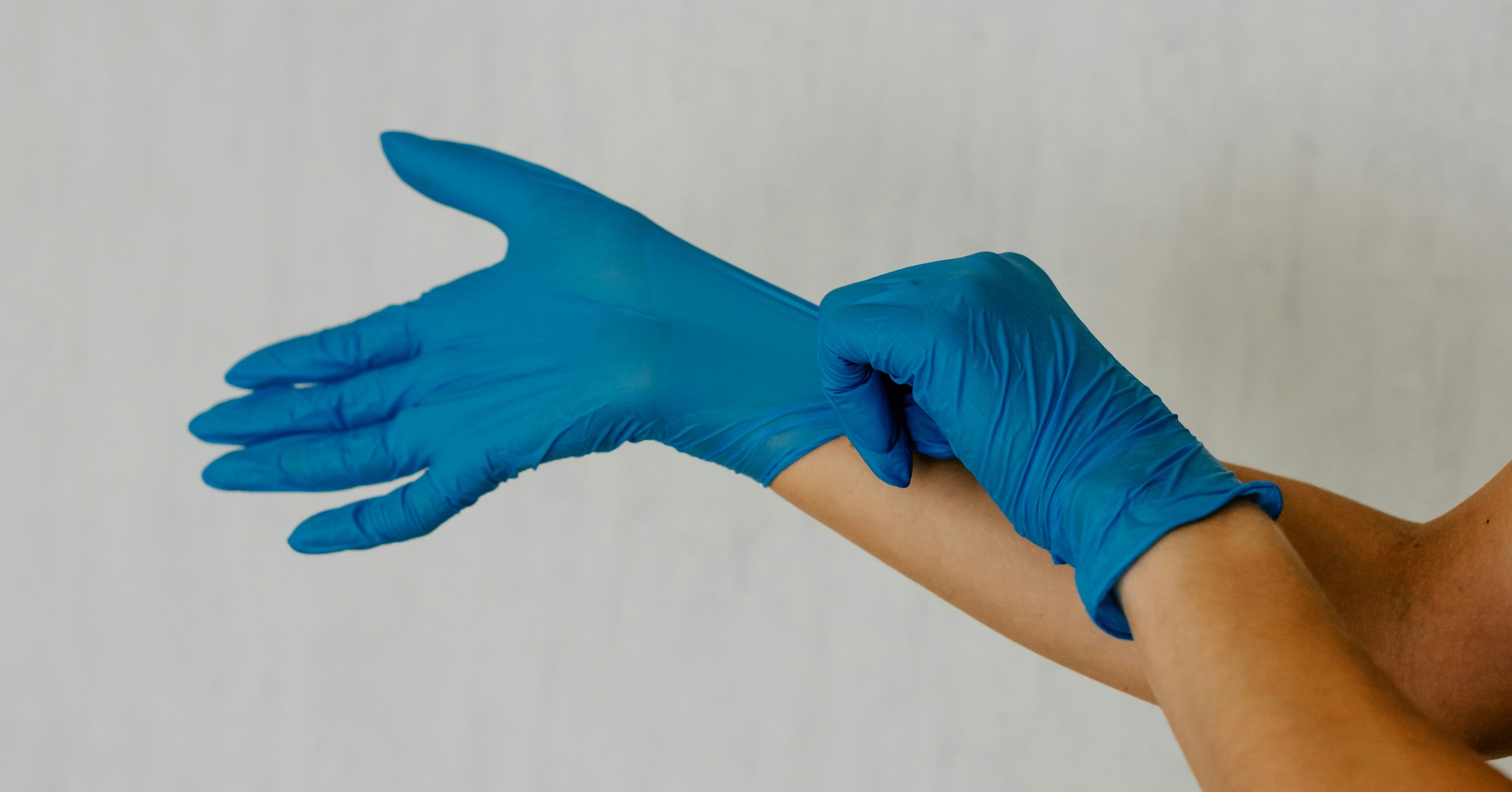 a person pulling on gloves to clean
