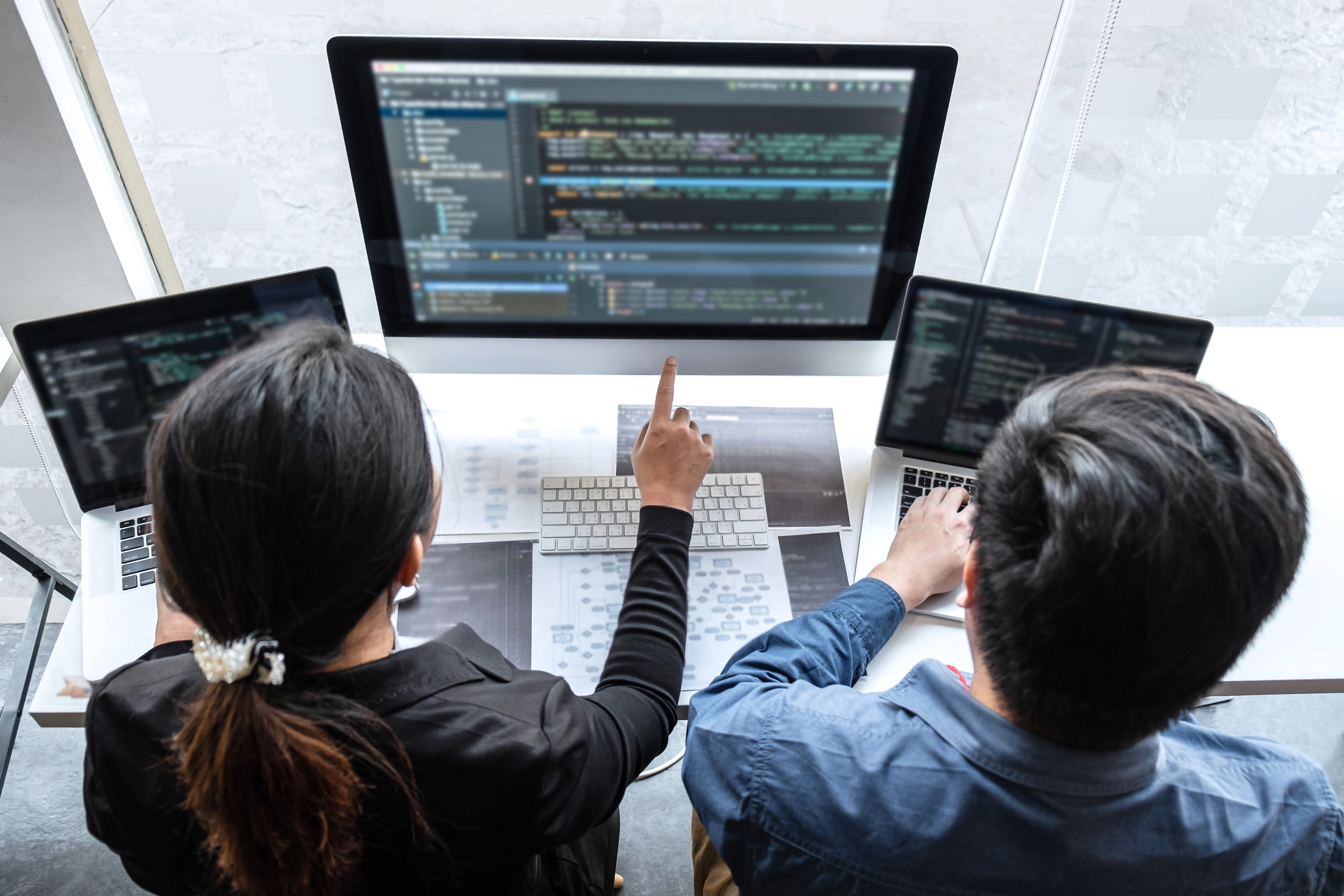 two employees pointing at a screen